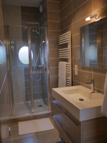 a bathroom with a sink and a shower at Résidence de Tourisme Central Parc Tours in Tours