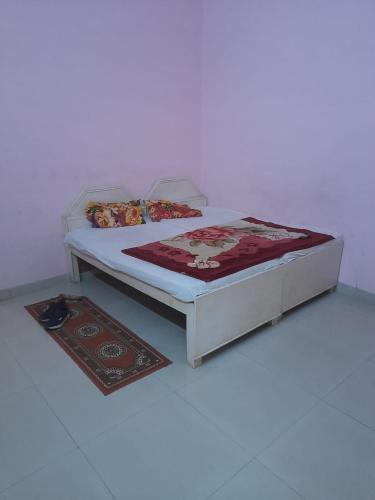 a bed in a room with two rugs on it at Hare Krishna hotel in Orchha