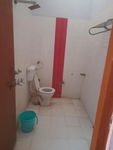 a bathroom with a toilet and a red shower at Hare Krishna hotel in Orchha
