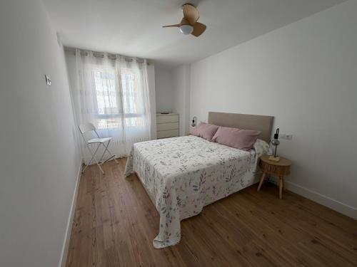 a white bedroom with a bed and a window at AMANITA VuT in Huerta del Rey