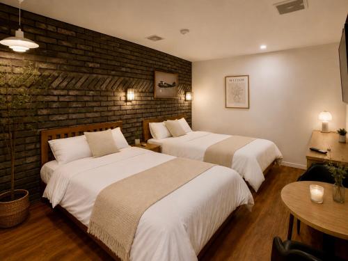 a hotel room with two beds and a brick wall at 힐링모텔 in Inch'ŏn-yŏk