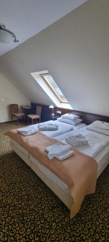 a large bed with towels on it in a room at Park Hotel in Hévíz