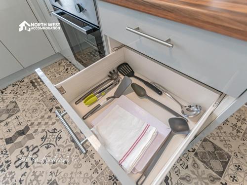 a drawer in a kitchen with utensils at Modern Serviced Apartments in St Helens with Free WiFi Ideal for Leisure or Work Stays by North West Accommodation in Saint Helens