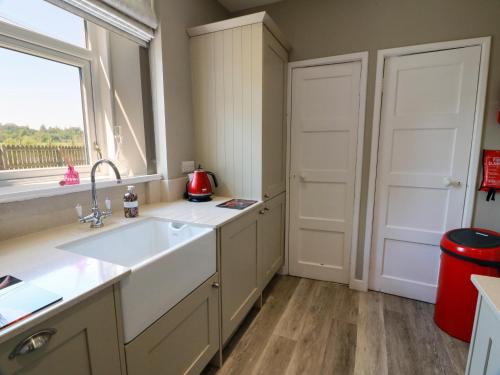 a kitchen with a sink and a window at Waterside Lodge in Lockerbie