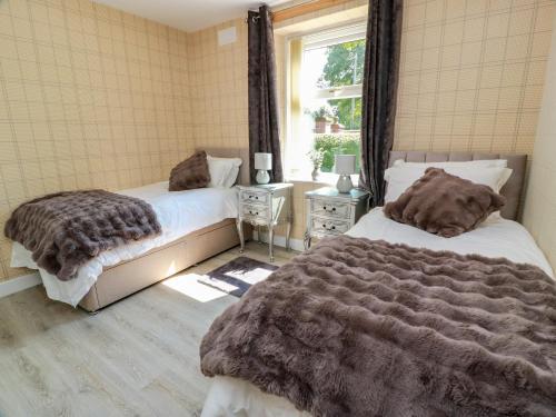 a bedroom with two beds and a window at Waterside Lodge in Lockerbie