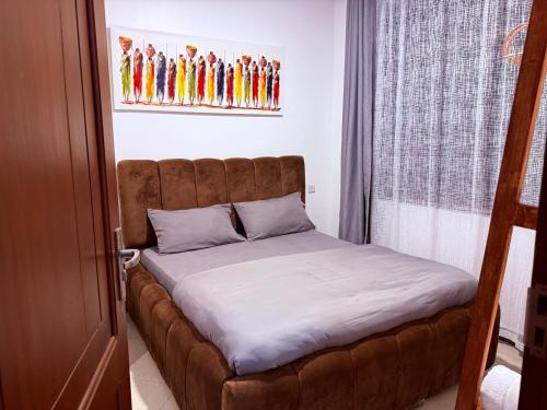 a bed in a room with a brown bed frame at Lunora Homes in Arusha