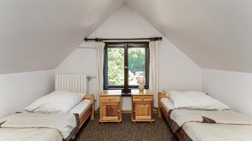 two twin beds in a room with a window at PAN Dom Pracy Twórczej w Wierzbie in Wierzba
