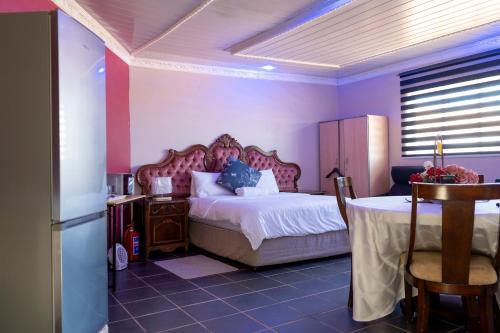 a bedroom with a bed and a table in it at Nairobi Guesthouse in Orkney