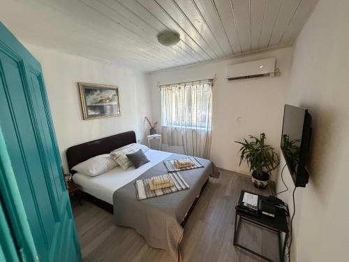 a small room with a bed and a tv at Apartment in Old Town with parking in Mostar