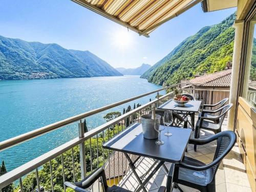 a balcony with two tables and a view of a lake at Apartment Miralago by Interhome in Oria