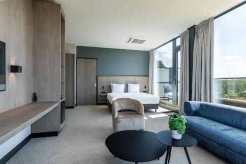 a hotel room with a bed and a couch at Alpine Hotel by SnowWorld in Landgraaf
