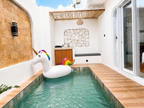 a pool with an inflatable unicorn in a house at Ayodhya Villa Patran in Kejayan