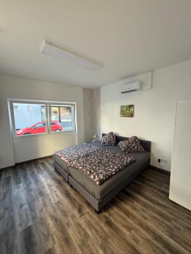 a bedroom with a bed and a large window at Sam Apartments LU/Oppau in Ludwigshafen am Rhein