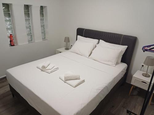 a bedroom with a white bed with two towels on it at Nára house 3 in Spata