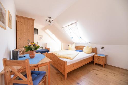 a small bedroom with a bed and a table at Frühstückspension Kleinschuster in Burgau