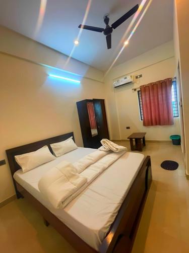a bedroom with a bed with a ceiling fan at GR Comforts Boarding and Lodging in Hirehalli