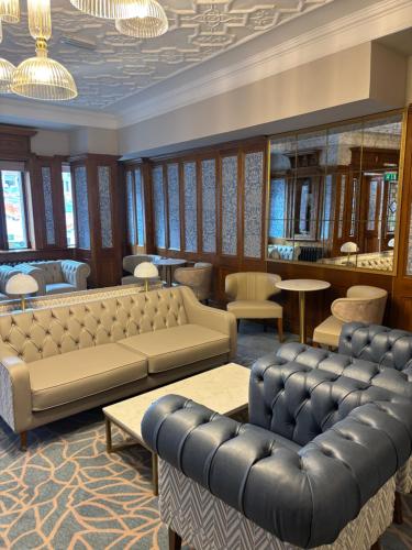 a waiting room with couches and tables and chairs at The Newgrange Hotel in Navan