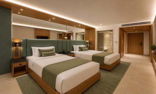 two beds in a hotel room with two beds sidx sidx sidx at The Crown Puducherry in Pondicherry