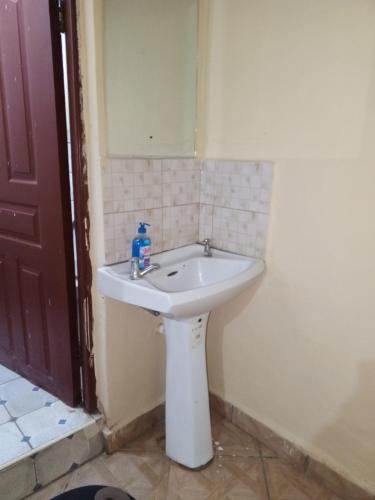 a white sink in a bathroom with a mirror at Voi town CBD homes in Voi