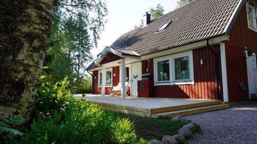 a red and white house with a porch at Landhaus Måsberget in Kristinehamn
