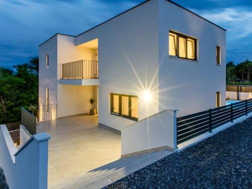 a white house with a deck at dusk at Villa Antica by Interhome in Lopar