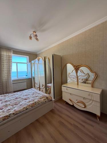 a bedroom with a bed and a dresser and a window at Sumgait Boulevard View Apartment in Sumqayıt