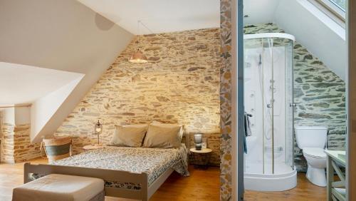 a bedroom with a bed and a stone wall at Gite champêtre in Tréal
