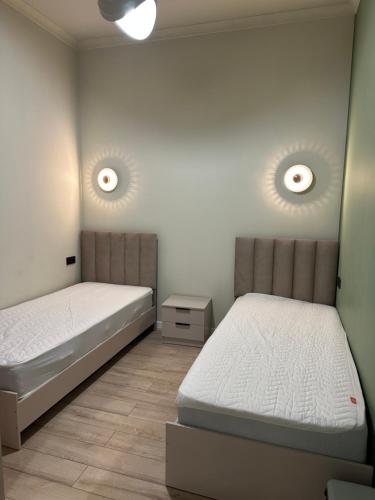 a bedroom with two beds and a night stand at Ademi cottage in Koshkolʼ