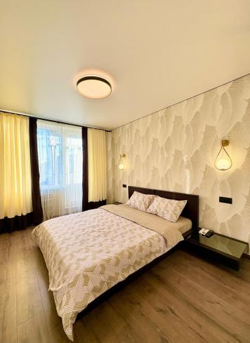 a bedroom with a large bed and a wall at Jacuzzi With light Nauki Avene in Kharkiv