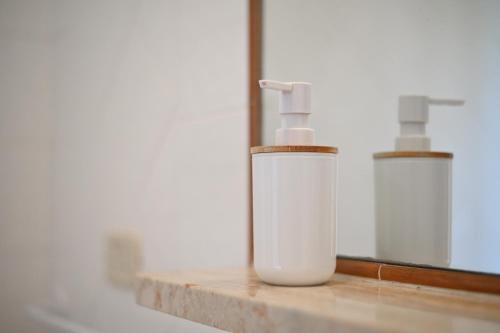 two white bottles sitting on a counter next to a mirror at Bed and Breakfast Torrette Etrusche in Capalbio