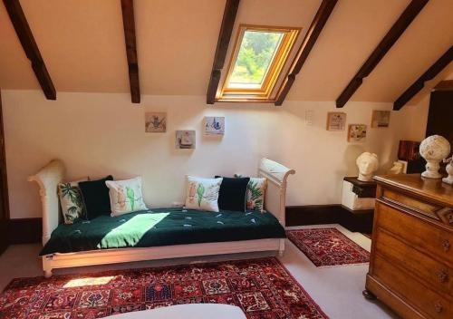 a bedroom with a green bed with a window at La Grange de Jeanne in Moosch