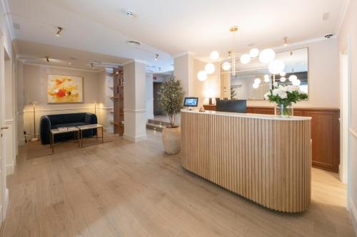 Un vestíbulo con mostrador de recepción y sala de espera. en Hotel Cisneros, en Alcalá de Henares