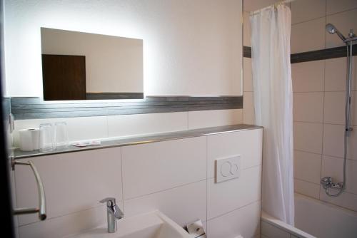 a bathroom with a sink and a mirror at Schinkels Brauhotel in Witzenhausen