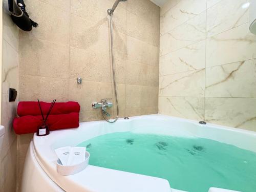 a bathroom with a bath tub with a shower at Jacuzzi With light Nauki Avene in Kharkiv