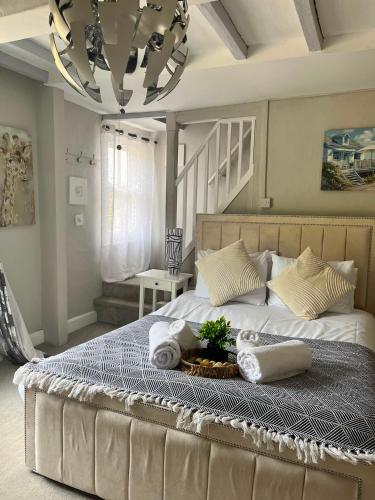 a bedroom with a large bed with towels and a chandelier at The Bickerton Poacher in Higher Burwardsley