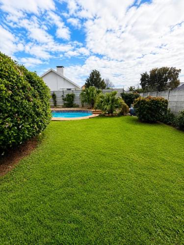 a yard with a swimming pool and a house at Three on Firmount in Somerset West