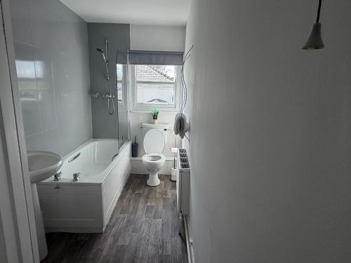 a bathroom with a tub and a toilet and a sink at The Bickerton Poacher in Higher Burwardsley