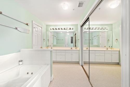 a white bathroom with a tub and two sinks at BCBPV1411 Ballast Point in Manteo