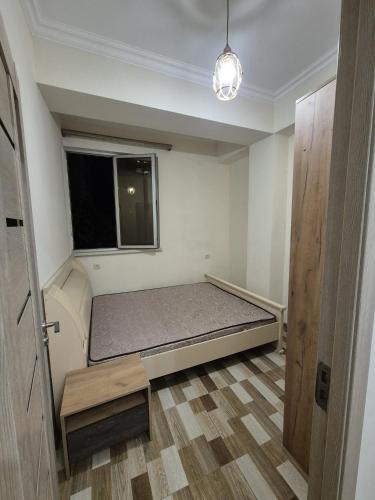 a small room with a bed and a window at At home in Yerevan