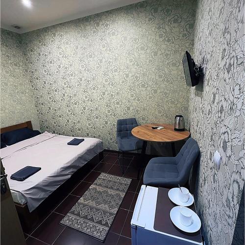 a small room with a bed and a table and chairs at Mini Hotel Leon in Lalovo