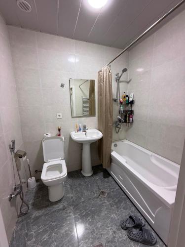 a bathroom with a sink and a toilet and a bath tub at Sumgait Boulevard View Apartment in Sumqayıt
