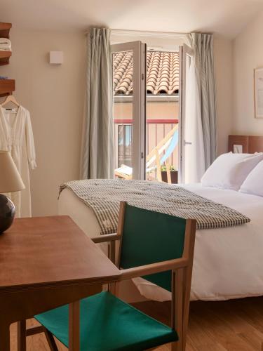 a bedroom with a bed and a table and a window at Alfred Hotels Toulouse Victor Hugo - Hôtel Rénové in Toulouse