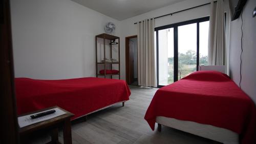 a bedroom with two beds and a large window at Casa do Sol in Diamantina