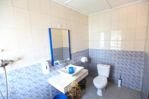 a bathroom with a white toilet and a sink at Le Port Hotel in Fort Dauphin