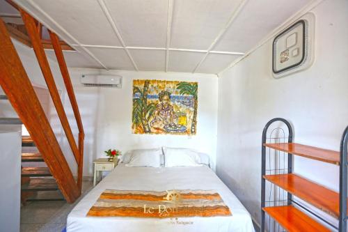 a bedroom with a bed with a painting on the wall at Le Port Hotel in Fort Dauphin