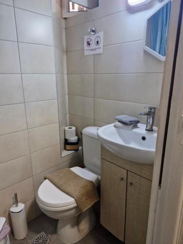 ein kleines Badezimmer mit Toilette und Waschbecken in der Unterkunft Central Spot 9 in Korfu-Stadt
