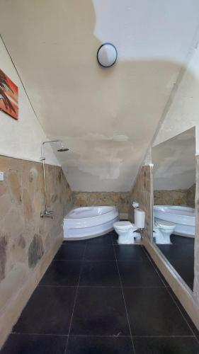a bathroom with two toilets and a bath tub and a tub at I love Amboseli in Kimana