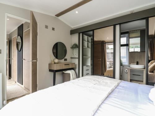 a bedroom with a large bed and a mirror at Lakewood Plot 2 in Clacton-on-Sea
