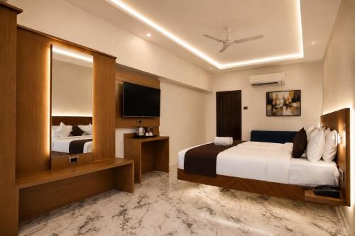 a hotel room with two beds and a television at The Blue Inn Hotel in Hyderabad