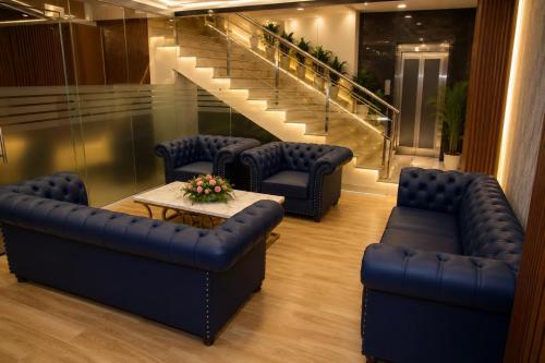 a lobby with couches and a table and stairs at The Blue Inn Hotel in Hyderabad